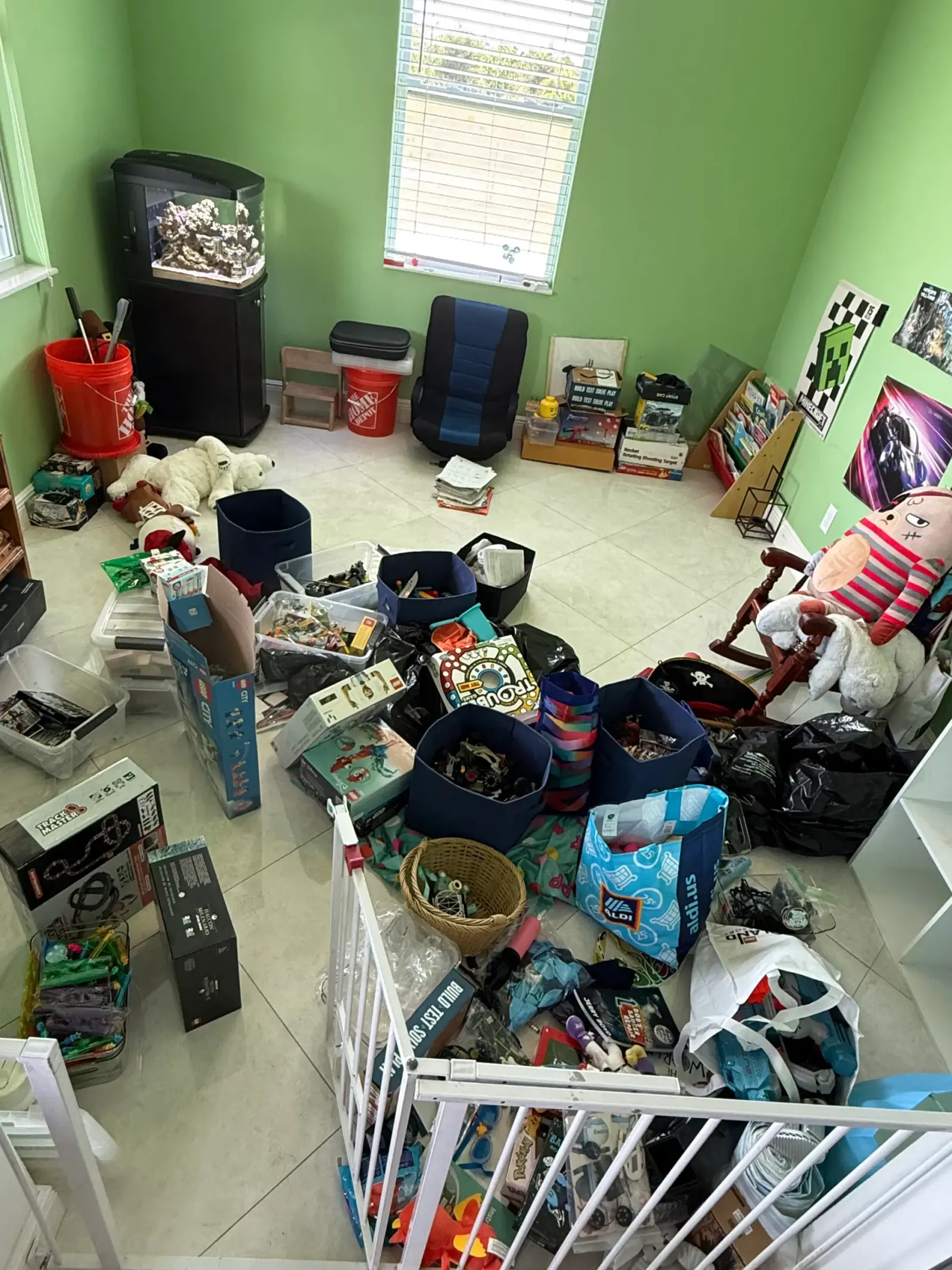 A playroom with toys, bins, boxes, and books gathered across the floor before a Tidying Naples organizing session