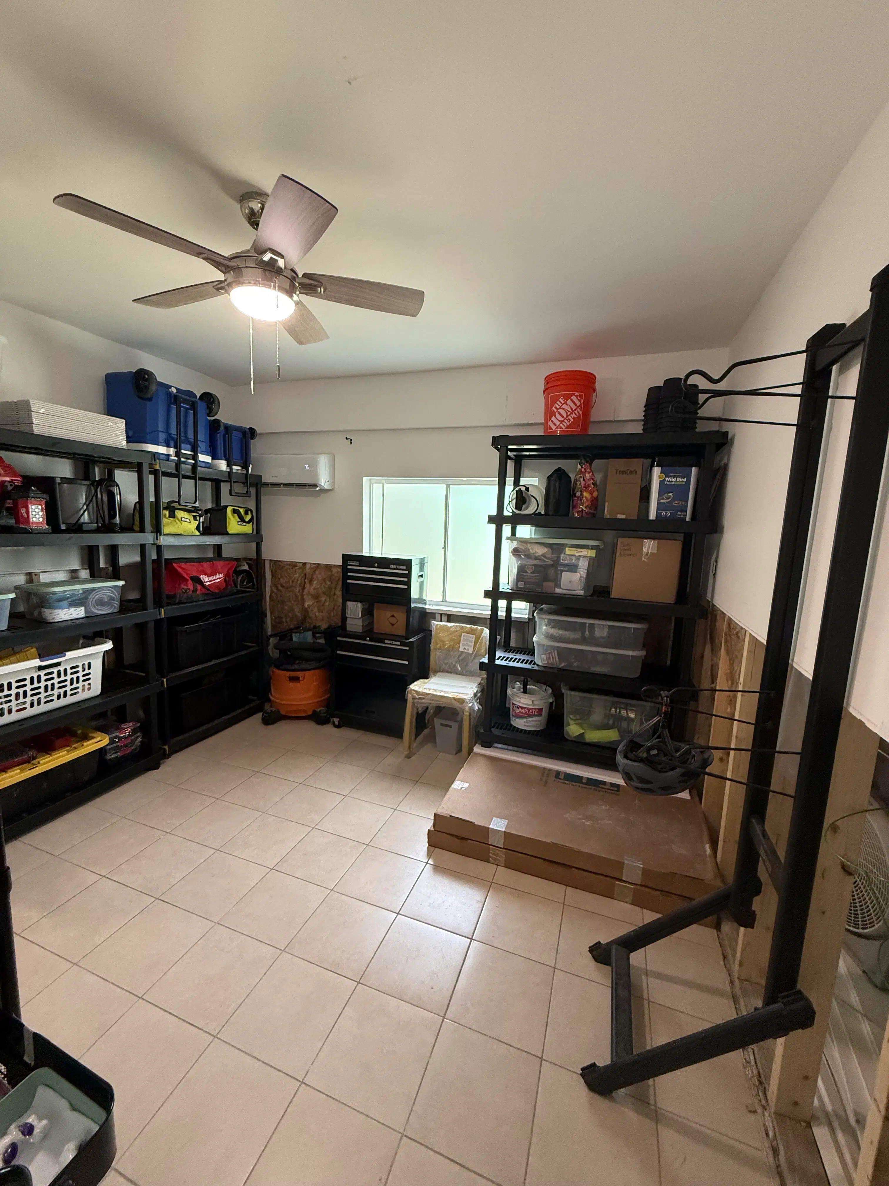 A utility and storage room with sturdy shelving, grouped equipment, and open floor space for easier access