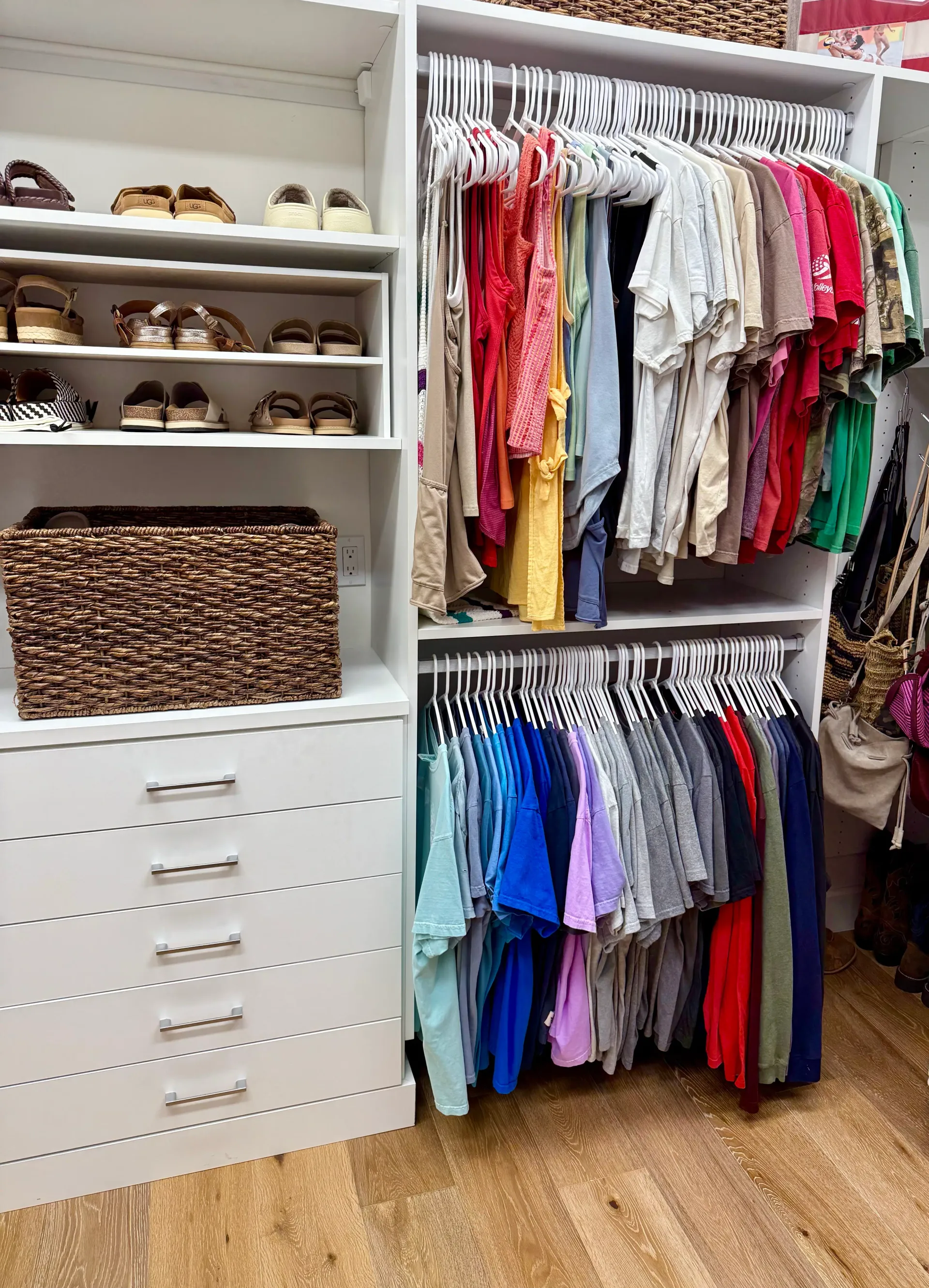 An organized reach-in closet with clothes on hangers, paired shoes on shelves, and everyday clothing arranged for easier reach and return