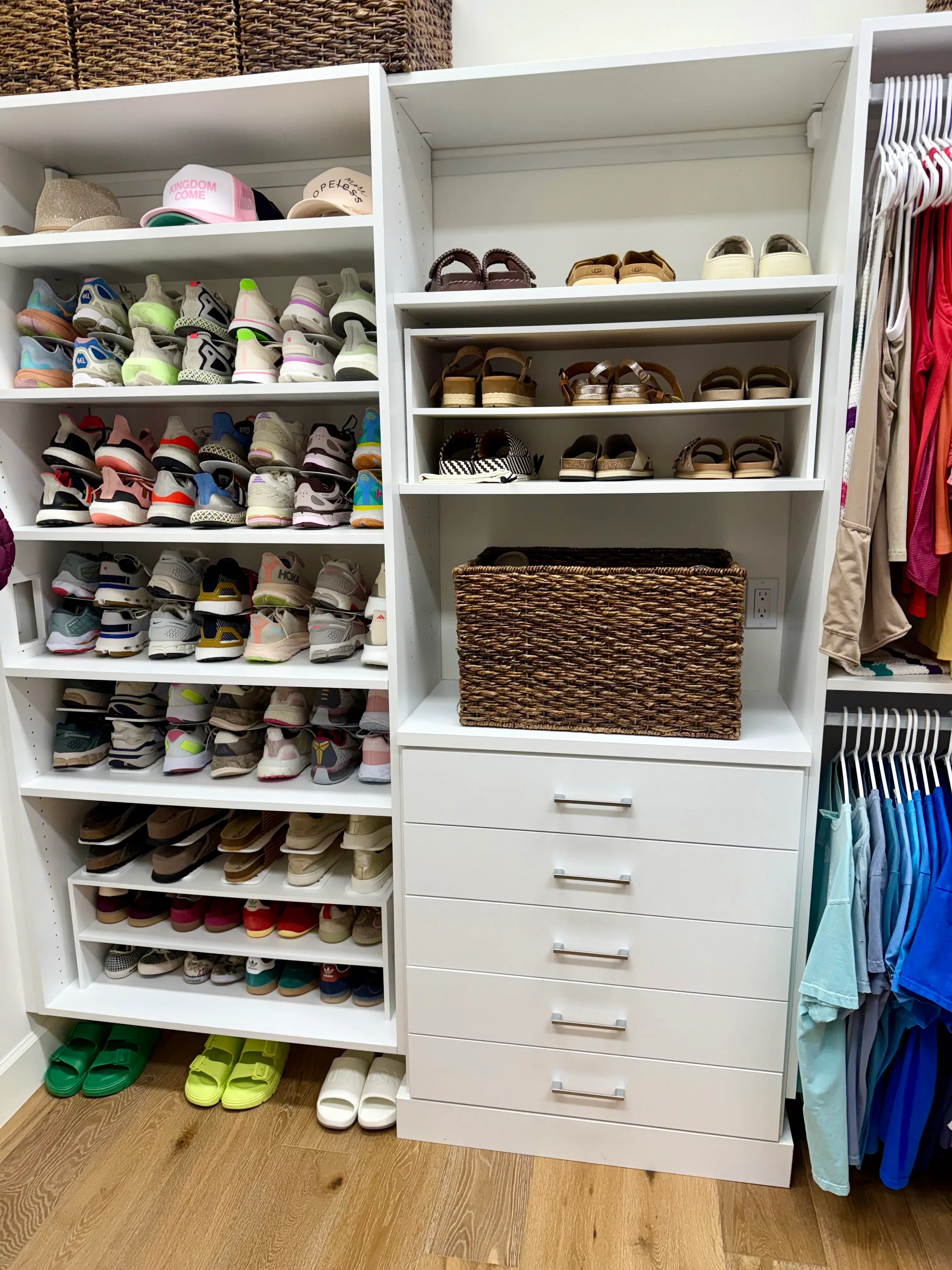 A walk-in closet with shoes paired on shelves, folded items grouped, and clothing arranged by section for easier reach